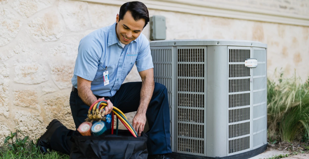 HVAC technician servicing outdoor AC unit