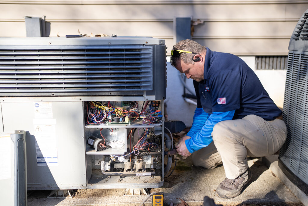 Technician repairing outdoor HVAC unit